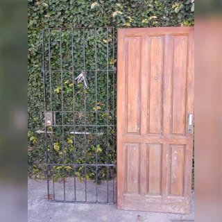 Puerta de madera con puerta reja de hierro